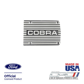 Front view of Cobra A/C compressor cover plate with machined aluminum finish and engraved COBRA logo for Ford small block engine applications, CPC part ENG-000-484.