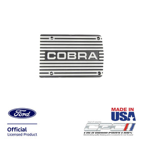 Front view of Cobra A/C compressor cover plate with solid COBRA lettering, black finish and brushed machined fins for Ford small block engine applications, CPC part ENG-000-515.
